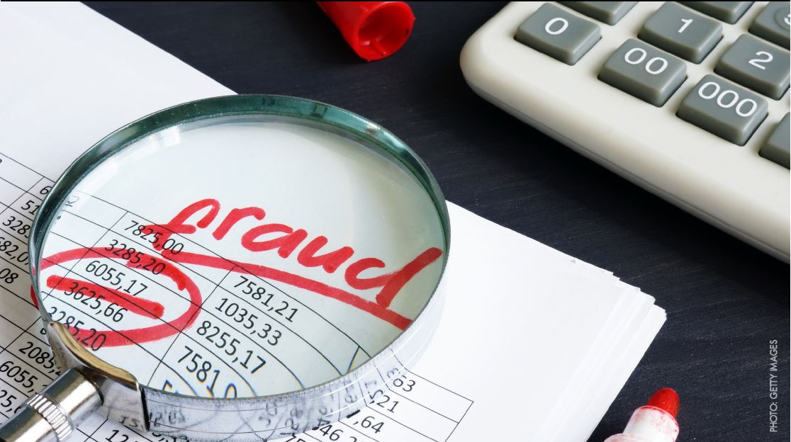 The word fraud underlined in red and numbers on paper.